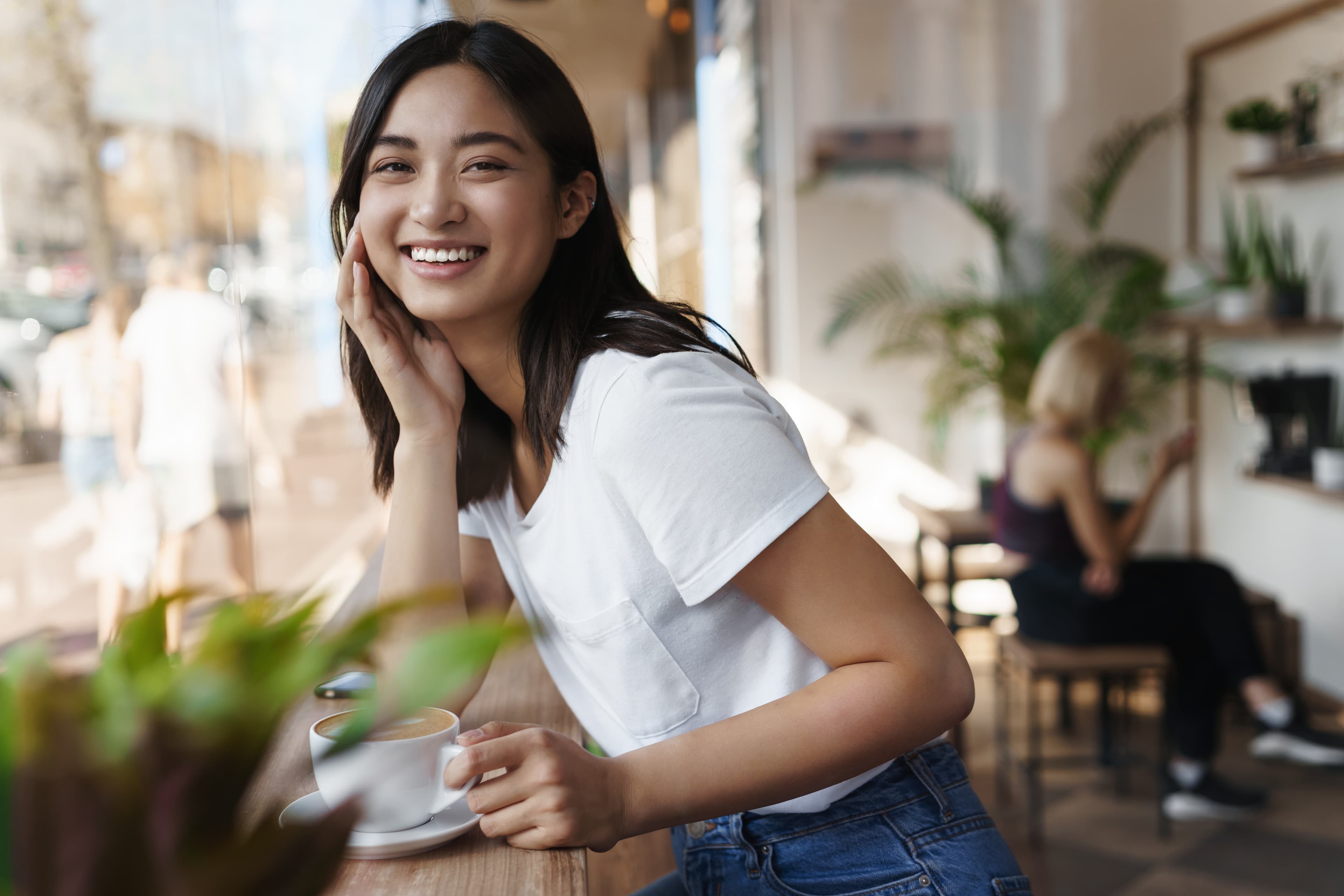 Smiling woman sitting at a cafe table.